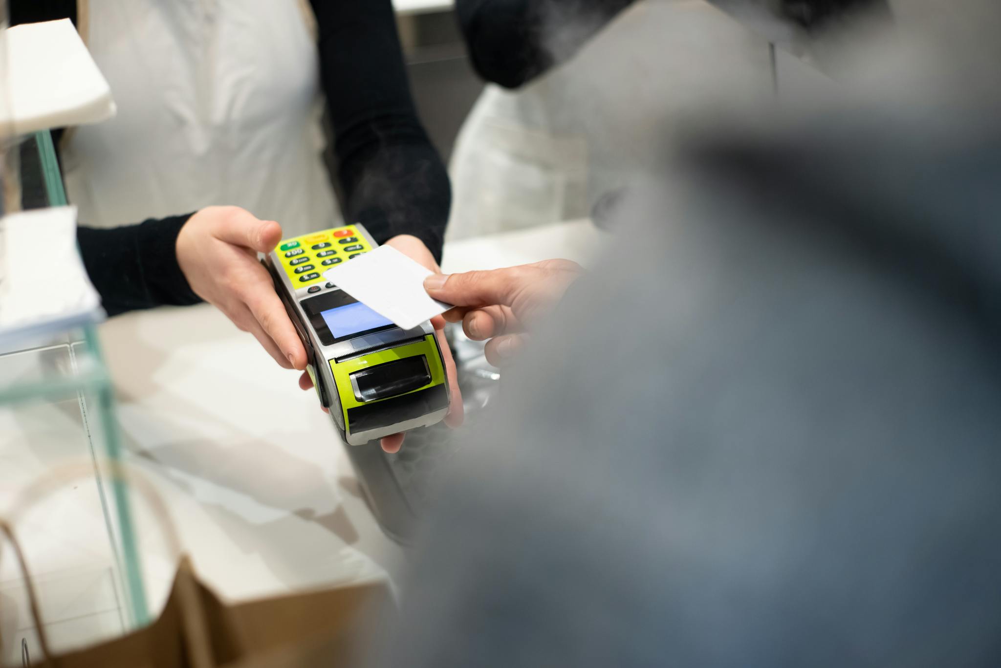A customer pays with a card at a payment terminal in a modern retail store.